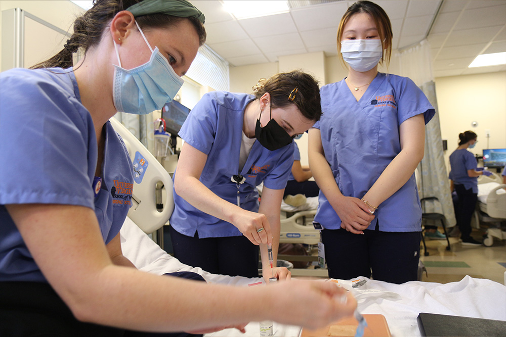 Members of the CNL Class of 2023 practice their nursing skills in the sim lab.