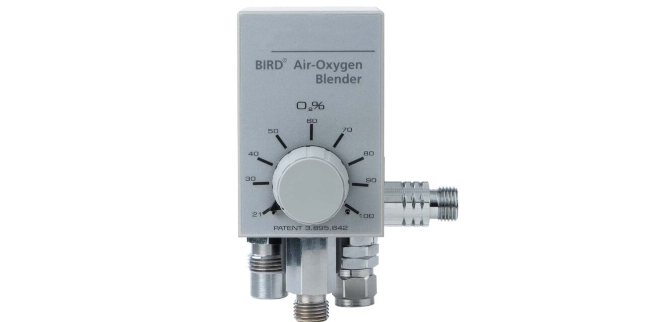 A medical gas regulator with a large control knob and multiple hose connections.