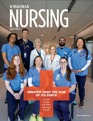 Eight medical professionals in scrubs and lab coats smile in a hospital hallway, with a large orange cross graphic and text 